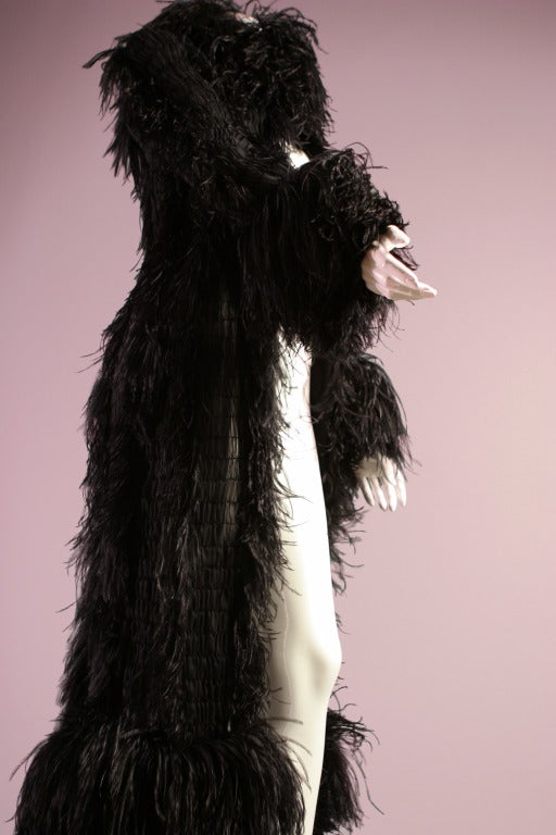 CHANEL, por Karl LAGERFELD, alta costura, hacia 1990.

Un sublime y vaporoso abrigo de noche de gasa de seda negra fruncida y plumas de avestruz bordadas. 
 Magistralmente fruncida, la gasa está adornada con plumas delicadamente ensambladas