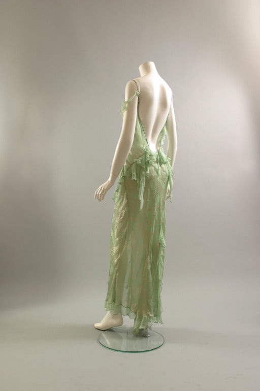 Christian DIOR, by John GALLIANO

A long and delicate, Nile green, silk and silver lurex, see trough chiffon evening sheath, bias cut, adorned with plain Nile green silk chiffon flounces front and back, thin asymmetric straps, front opening to the
