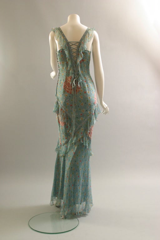 Christian DIOR boutique, by John GALLIANO, circa 2003

A lovely printed silk chiffon, long evening sheath. Adorned with an adjustable front and back laced bodice, plain blue chiffon flounces to the front and back décolleté, and to the lower