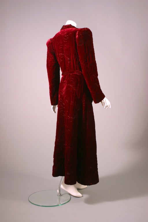 MARGARET, 9 rue de la paix, Paris, circa 1940

Fabulous crimson silk velvet bath robe, entirely padded and quilted , lined with a salmony pink crepe de chine, matching belt with fantastic pompoms, padded shoulders...
Extremely heavy and