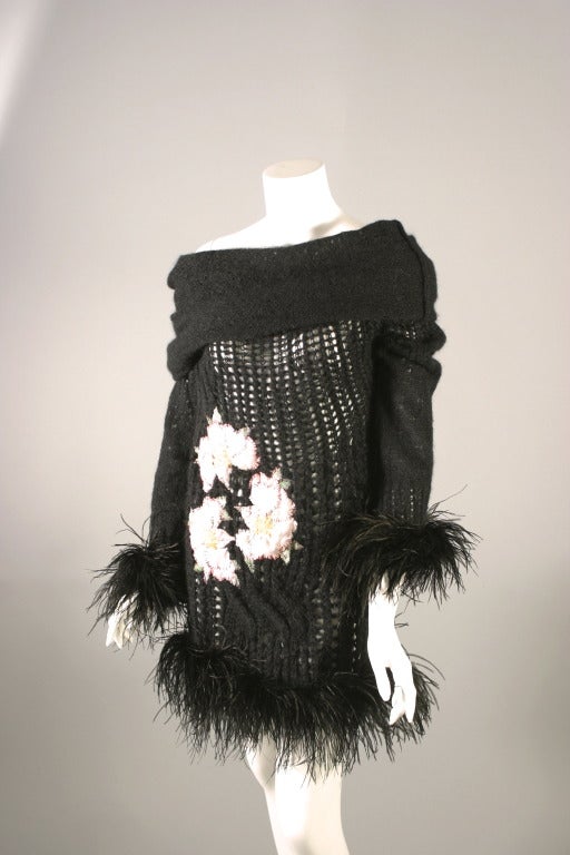 Christian DIOR boutique, by John GALLIANO, circa  2004

A lovely short black mohair knitted dress or tunic, fancy knitting.
Application centre front of a silk patchwork figuring three flowers. The long sleeves and hem adorned with ostrich