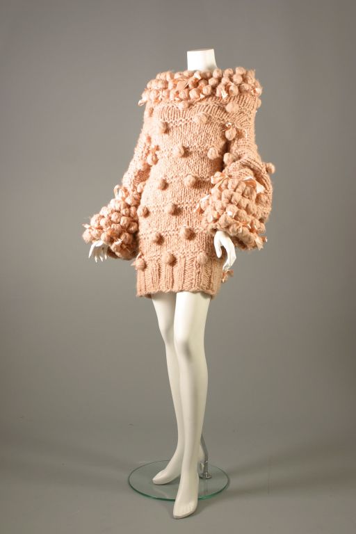 JOHN GALLIANO, circa 2004

Marvelous ample tea rose wollen maxi jumper, cross shaped, three quarter sleeves, adorned like russian brides with large matching pompons and matching satin ribbon forming bows. Beautiful fancy knitting ...
latex label,