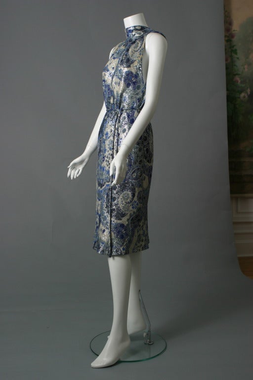 Jacques Griffe, haute couture, circa 1950

Superb evening ensemble from this so talented couturier...!
Composed of a sleeveless lamé dress with a deep draped cowl  at the back, knotted at the waist, it is worn over a skirt, being of plain gray