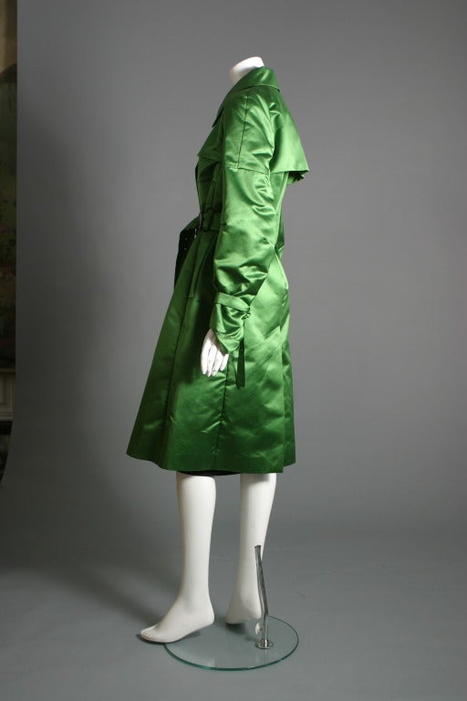 CELINE, Paris, 
Labelled 

Superb emerald green silk satin recent trench coat, tightened around the waist and the wrists by C initials in old silver metal, two pockets, Six buttons, raglan sleeves, no lining.
US size 6
Delivery