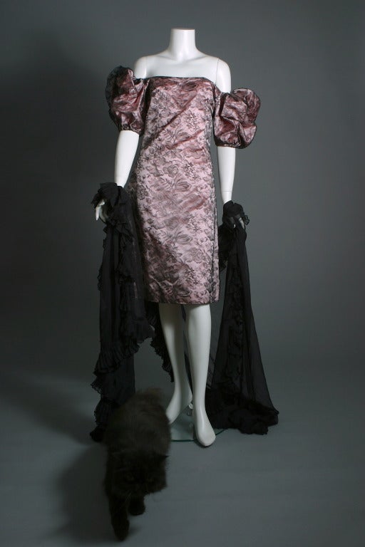 Givenchy, ( attributed ), haute couture, circa 1980, un- labelled

Very glamorous couture sheath, the heavy soft pink silk satin ground adorned with a very fine shimmering Marescot lace. Puff sleeves, zip closure at the back
Approx. US size