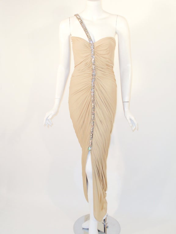 This is a sophisticated cocktail dress from Elizabeth Mason Couture made of a nude silk jersey knit that is ruched down the front and has a rhinestone center piece that becomes the strap of the dress.

This is a couture custom order and is available
