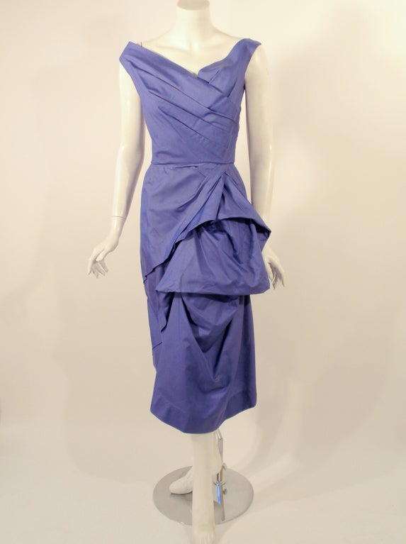 This a sleeveless vintage cocktail dress from Ceil Chapman. It is made of taffeta and has a crossing pleated bodice and ruched and draped straight skirt. There is a metal zipper up the back.

Measurements: 

Bust: 36