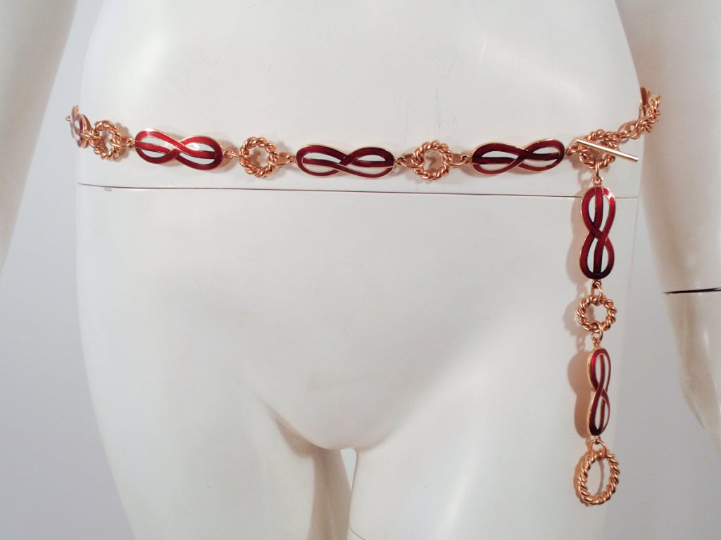 This is a great belt made by Gucci. It is a gold tome metal with burgundy and white enamel in an infinity symbol shape. this belt is fully adjustable to size.

Measurements:

39