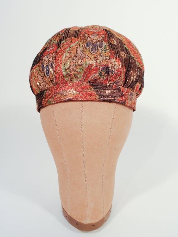 This is a great vintage bubble hat made by Jean Louis and previously owned by Loretta Young. Made of a multi-color patterned fabric with gold lurex woven in and a black lining.

Measurements: 

Size 7 (22