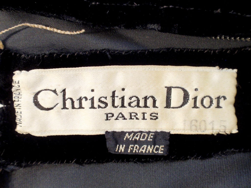 This is a custom Haute Couture cocktail dress from Christian Dior. 
It is a lovely fitted dress with a bow at the waist, made from a soft black velvet. 
(fabric appears to be silk velvet)
There is a metal zipper down the back.
The dress does not