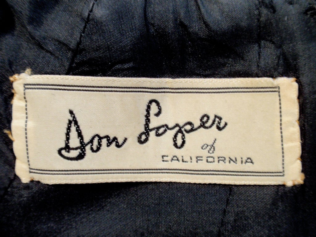 Este es un encantador vestido de cóctel vintage de los años 60 de Don Loper. Es una silueta de vaina con mangas largas y piel auténtica en los puños. Hay ribetes en las costuras princesa. Este vestido está totalmente forrado y tiene una abertura