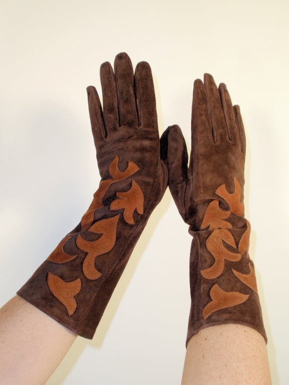 This is a fantastic pair of gloves from Yves Saint Laurent Rive Gauche. They reach to about mid forearm. Composed of a soft chocolate brown suede with lighter brown suede applique. Smooth grain leather interior (reverse side of suede).