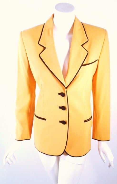 This Moschino Couture Yellow Jacket is perfect for the vintage collector looking for a piece that is fun and iconic. Design features black piping with three buttons across the front of the blazer, and four decorative buttons on each sleeve. The