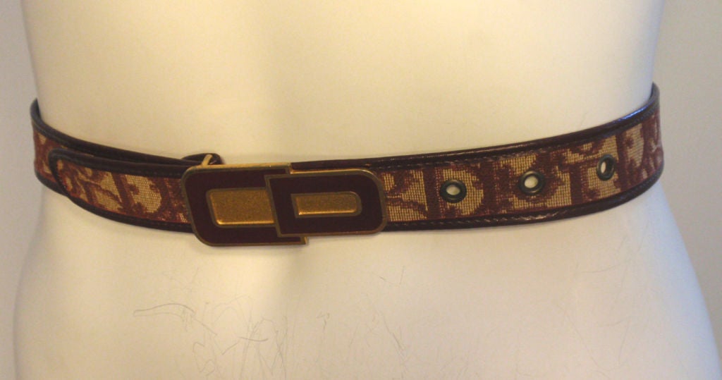 This is a vintage burgundy and cream monogram belt by Christian Dior, from the 1970's. It has a gold buckle with 