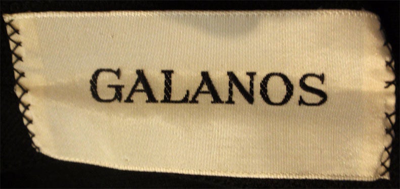 Si tratta di un abito nero vintage di Galanos, risalente agli anni '60. L'abito ha maniche arricciate a 3/4, scollatura quadrata, dettaglio a portafoglio con bottoni intorno alla vita e cerniera sul retro.

Misure:

Da spalla a spalla: