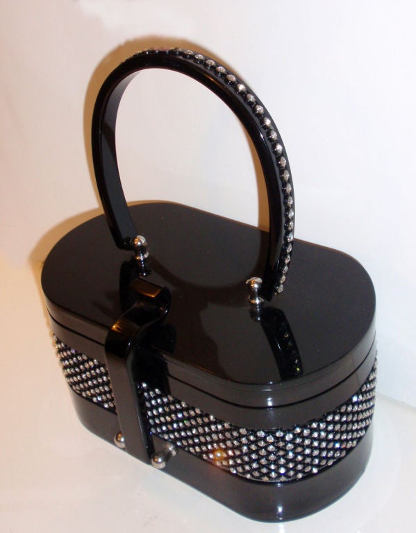 This is a very rare black plastic purse covered in rhinestones, from the 1950's. The purse has one 4.5