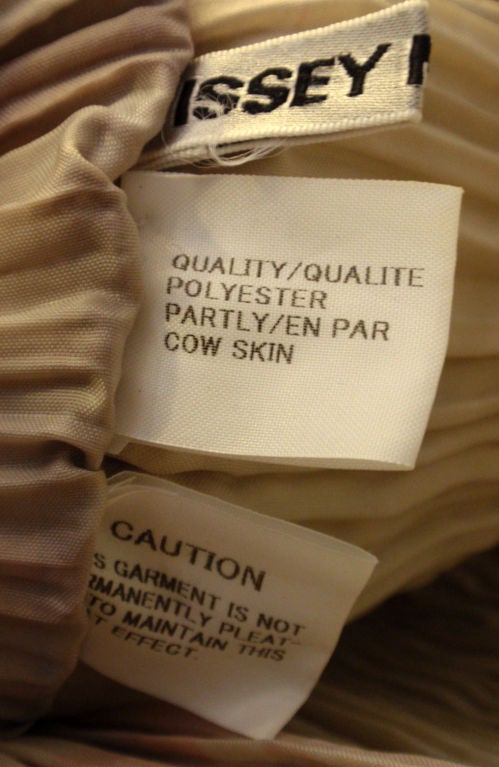 This is a plaid pleated shoulder bag by Issey Miyake, from the 1990's. The bag has one thin tan leather strap, and a button closure.<br />
<br />
Measurements:<br />
Height: 11 1/2