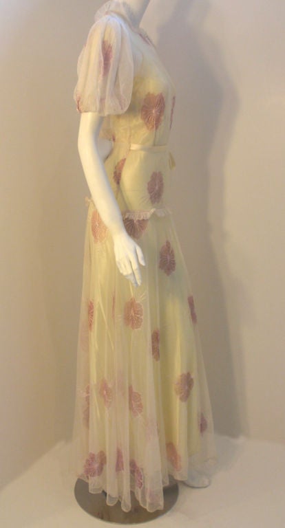 This is a custom made vintage two piece long cream thin tulle dress with embroidered pink flowers and a yellow silk slip, from the 1930's. The dress has a matching silk tie belt, snaps up the side seam, and an open slit back.

Dress