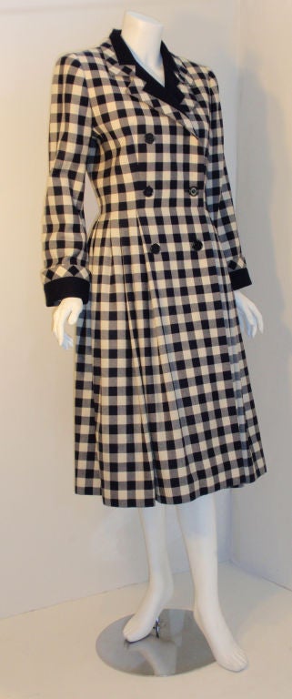 This is a navy and cream plaid wool coat or dress by Givenchy, from the 1980's. The coat/dress is double breasted with a fitted waist, pleats at the hip, navy blue silk lining, and side seam pockets.

Measures:

Length: 44