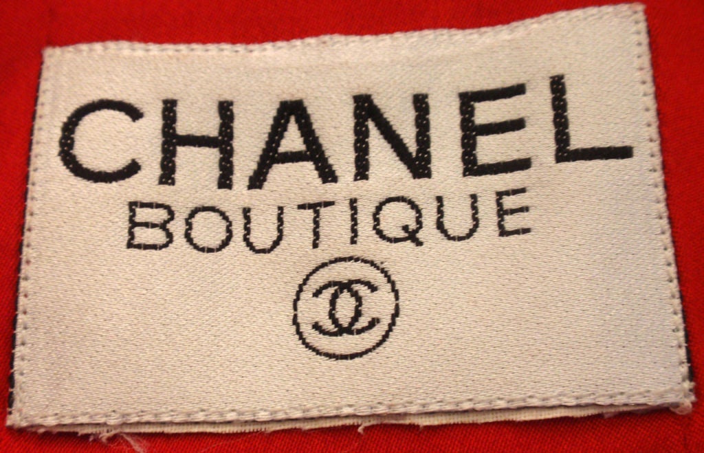 This is a red coat with gold logo buttons by Chanel, from the 1990's. The coat has four red and gold logo buttons on the front and three on each cuff, with a red silk logo print lining.<br />
Measures:<br />
Length: 37
