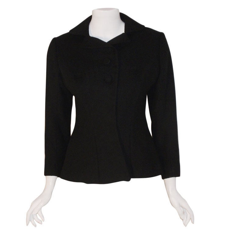 This is a very rare black wool blazer by Charles James, from the 1940's. The blazer has two buttons at the bust, a row of hidden snaps down the front, and beautiful design detail.

Measurements:

Length: 22 1/2