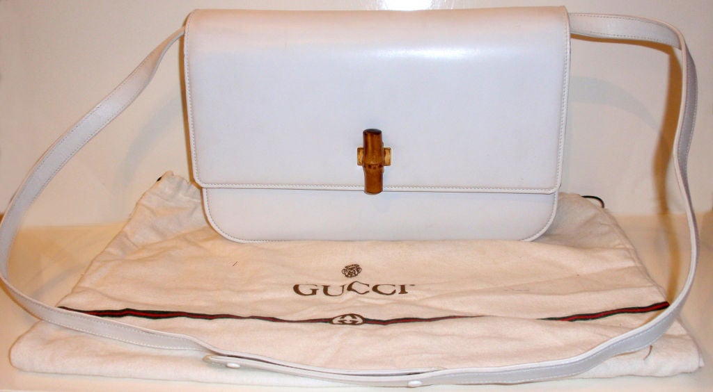 This is a vintage white leather clutch or shoulder bag by Gucci, from the 1980's. This bag has a detachable strap, a beige suede interior, two main compartments with an open pocket and a zipper pocket. Includes the original dustbag.<br />
<br