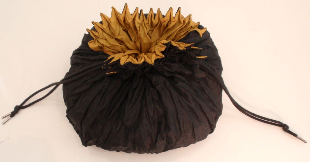 This is a black and gold reversible silk draw string bag by Issey Miyake, from the 1990's. The tag was removed to be worn on both sides.<br />
<br />
This bag by Issey Miyake is available to be viewed privately in our Beverly Hills boutique