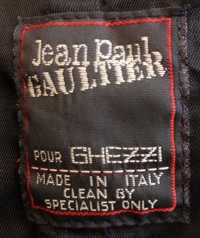 This is a black leather jacket with colorful embroidery detail by Jean Paul Gautier, from the 1980's. The jacket has a front zipper and a short waist.<br />
<br />
Measures:<br />
Length: 13<br />
Shoulder to shoulder: 17