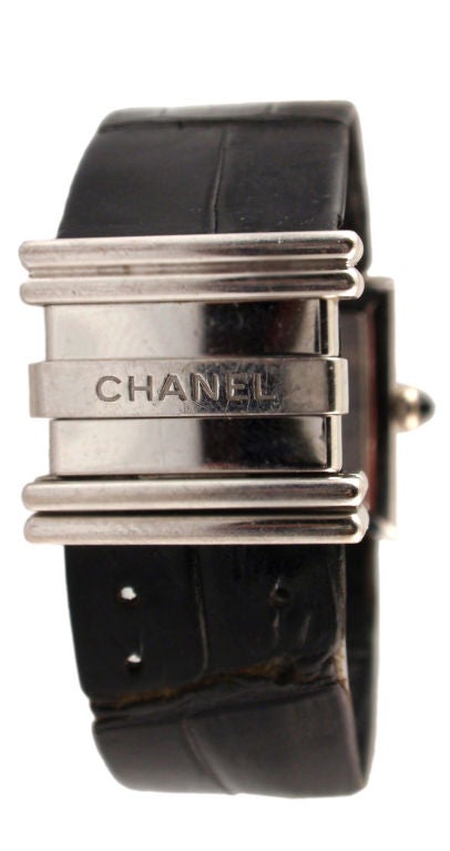 This is an 18K white gold watch with diamond baguettes by Chanel, from 1989. The watch has a square face with roman numerals and a black alligator wrist band. Includes the original box.<br />
<br />
This Chanel watch is available to be viewed