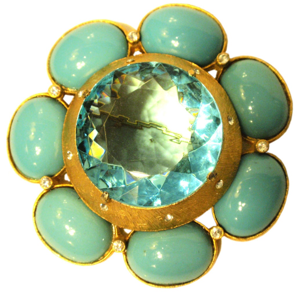 This is a gorgeous vintage flower pin by Brania, from the 1960's. The pin has one large light blue jewel, blue Turquoise color stones, tiny rhinestone detail, and gold hardware.

Measures: 3