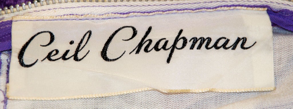 Dies ist ein Sammlerstück Vintage lila, violett, grün und Creme weich poliert Baumwolle Blumendruck Tag Kleid von Ceil Chapman, aus den 1950er Jahren. Das Kleid hat einen Wickelschlitz auf der Vorderseite, eine drapierte Taille mit Schleife, ist