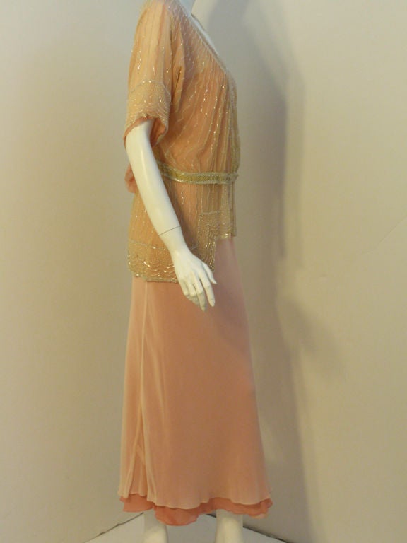 This is a highly collectible vintage Beaded Jacket from the 1920's, blousey at the bust with a drop waistline. It is made of a pale yellow French net with a pink silk chiffon lining. There is a lot of hand bead work  This piece is museum quality. It