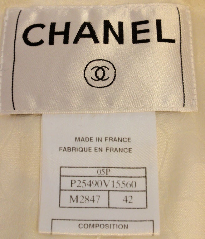This is a white jacket with faux pearl logo buttons and sequins all over by Chanel, from the 1990's. The jacket has two small pockets in the front, bell cuffs, and a cream floral logo print lining.<br />
<br />
Measurements:<br />
Size #42<br