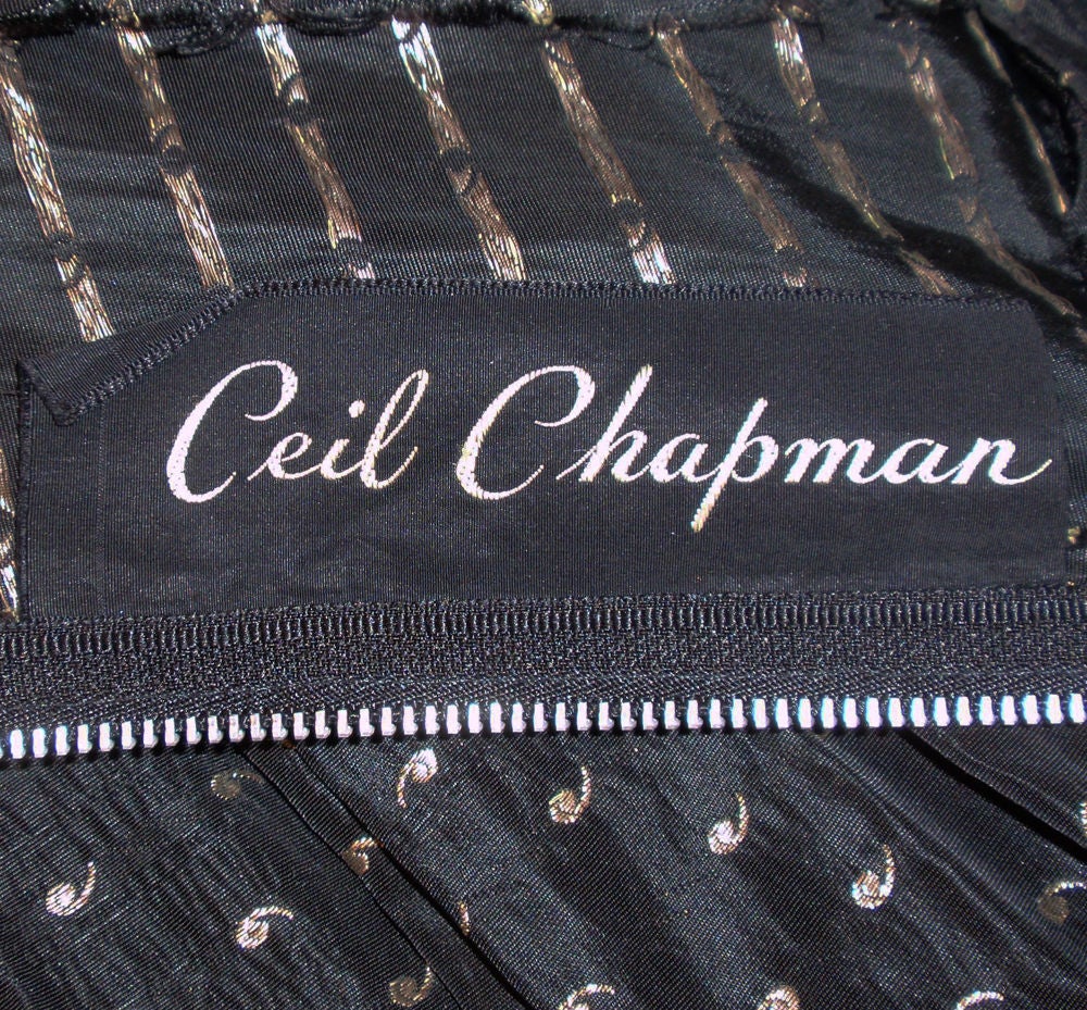 This is a gorgeous and collectible vintage Ceil Chapman evening gown. It is made of a black taffeta with gold swirls woven into the fabric. It has a very unusual shawl 