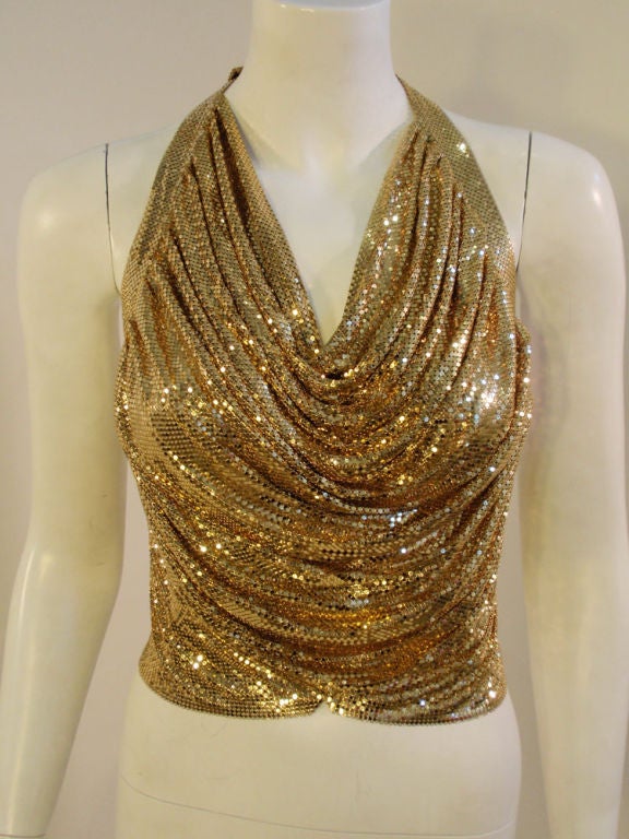 This a great halter top from Ferrara. It is made entirely of a gold metal mesh that drapes in the front, with gold leather ties on the back. It attaches at the back of the neck with a hook and can be made adjustable.<br />
<br />
Measurements:<br