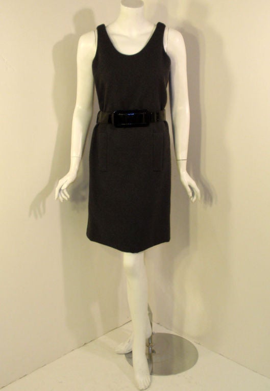 This is a classic looking day dress from Geoffery Beene. It is made from a thick grey wool knit and has a faux patent leather wide belt (by Acme belts). There are 2 pockets in the front and a side zipper. Line in black silk.
Second label near the