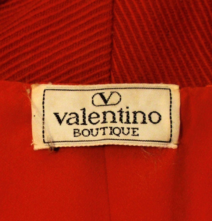 This is a smart looking skirt suit from Valentino, made of a red corded fabric with a matching red rayon lining. The jacket has a great pin tuck detail on the back and the skirt is a pencil style.<br />
<br />
Measurements:<br />
<br