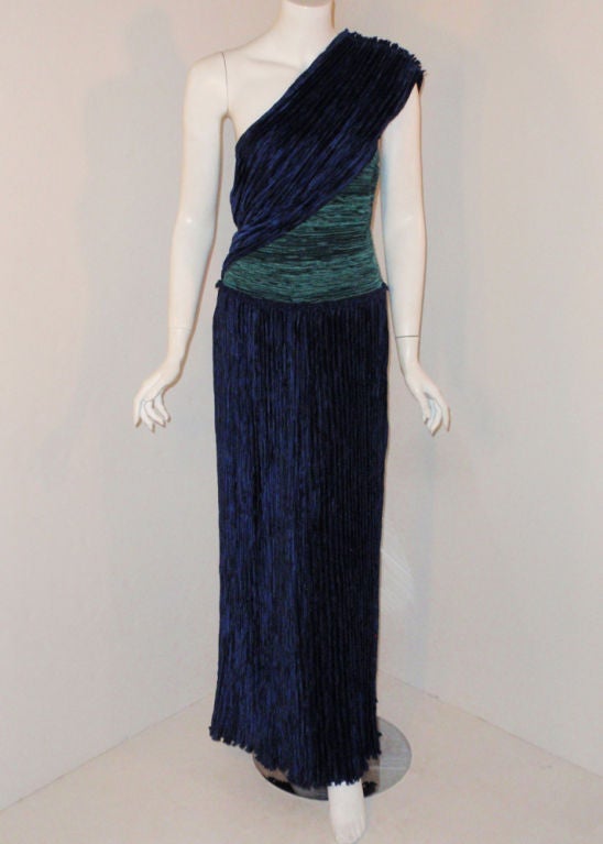 This is a very elegant one shoulder gown from Mary McFadden. It is made from a pleated nylon fabric, with a fitted bodice and straight skirt. The pleated give it lots of movement. There is a side zipper and a grosgrain strip inside the waist