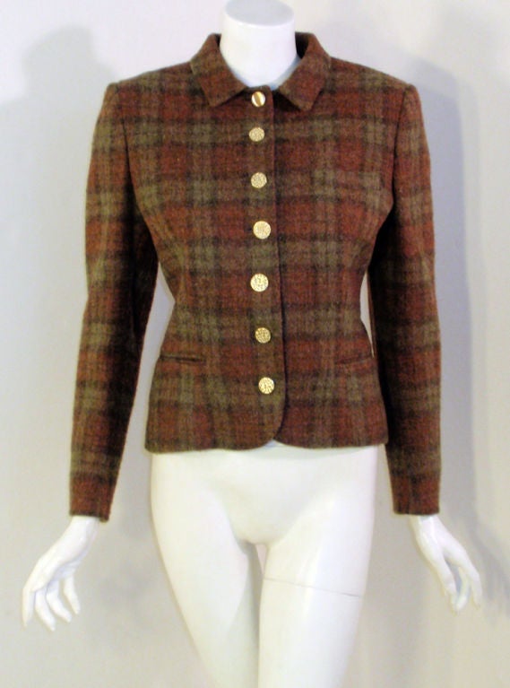 This is a classic fitted blazer from Pierre Cardin. It is made of a brown, rust and olive green plaid wool, with bright gold metal buttons.

Size 8

Measurements:

Length(Shoulder to hem): 23