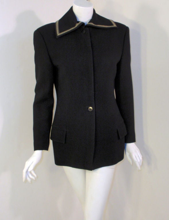 This is a lovely tailored jacket from Gianni Versace. It is made of a black wool crepe with a nylon lining. It is all black in color, except for the gray stripe detail at the collar. The buttons down the front are hidden.

Size 8 us/ 42