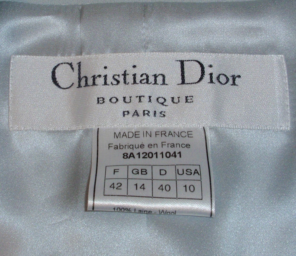This is a smart looking 2 piece skirt suit from Christian Dior. It is made of a light periwinkle blue wool with a matching silk lining. This suit has a fitted single button blazer with faux padded pockets, and a straight pencil skirt. Both jacket