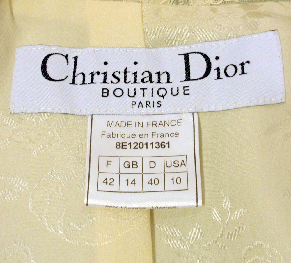 This is a charming 2 piece skirt suit from Christian Dior. The entire ensemble is made from a mint green colored viscose and lined blend floral jacquard fabric, with a cream colored silk lining. There is lace detail on the collar of the fitted