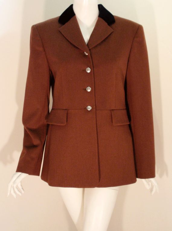 This is a fine women's jacket from Hermes. It is made of a soft brown wool with a brown silk lining and a black velvet collar. There are 4 metal logo buttons on the front and 2 on the back. there are also buttons at the cuffs.<br />
<br />
Size 42