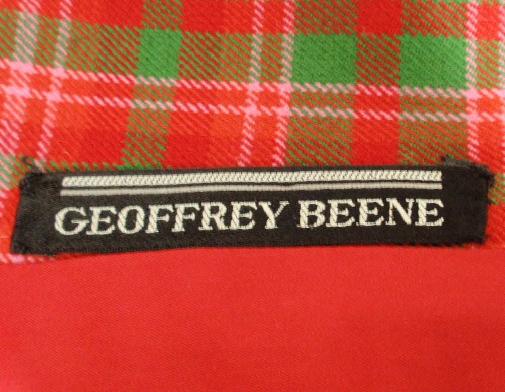 This is an adorable vintage 2 piece dress and coat ensemble from Geoffrey Beene. It is made of a red green and pink plaid wool, and the dress has a green bodice with the same plaid skirt.<br />
The coat is a swing style with a big pleat on the back