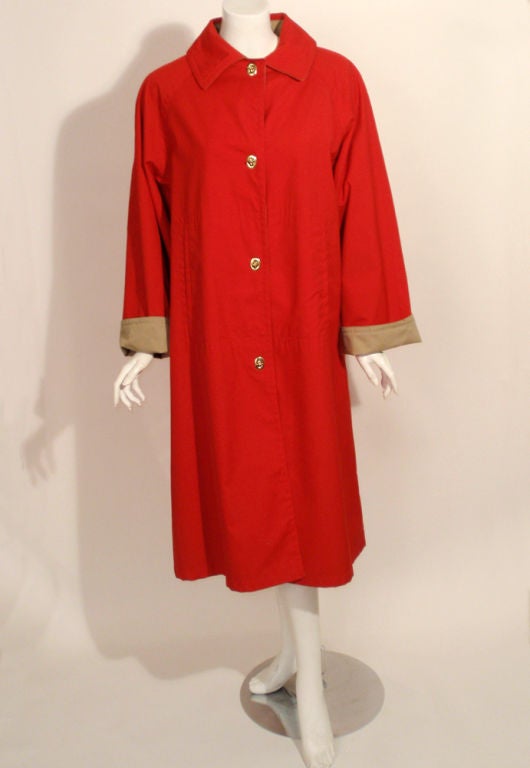 This is a stylish raincoat from Bonnie Cashin. It is made of a red cotton canvas with a tan canvas lining. The sleeves can be worn cuffed or down for a different look. The closures are a gold metal that twist open and closed.

Size: 16