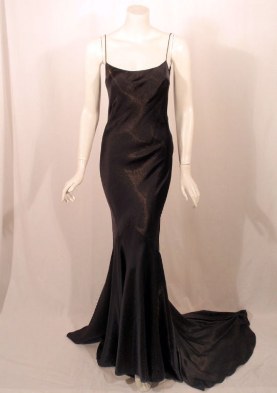 This is a very elegant evening gown from John Galliano, circa 1997. The label has been removed but it is authentic. This dress  is bias cut and made with a dark navy satin that has a lot of drape and flow. It has very thin spaghetti straps and bra