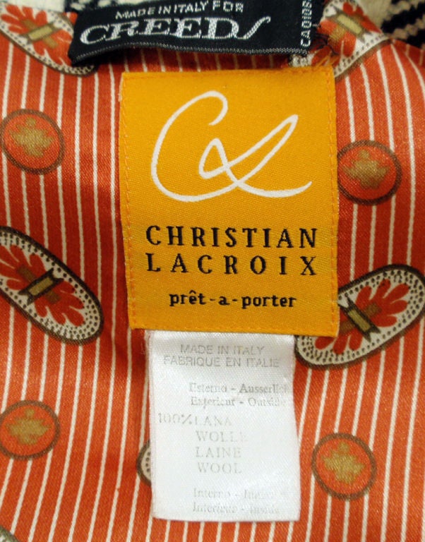 This is a very classy skirt suit from Christian Lacroix. Both the jacket and the skirt are made with a multi-colored houndstooth patterned wool, with a jazzy printed lining. The skirt is a high waisted pencil style that come above the knee and has 2