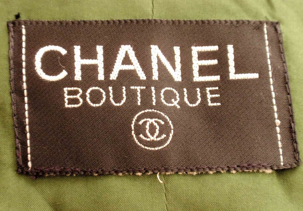 This is a green tweed and multi colored jacket with green velvet trim detail by Chanel, from the 1990's. The jacket has an open front, fringe detail, four front patch pockets, three gold logo buttons on each cuff, and a green silk lining.

Length: