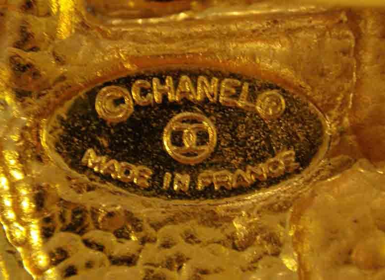 This is a gold logo crest three strand chain link belt by Chanel, from the 1990's. The belt can adjust to fit the waist or hips. The total length of the belt is 34 1/2