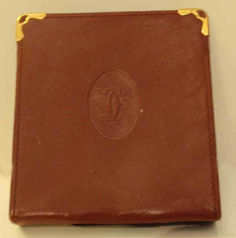 This is a vintage burgundy leather cigarette case with gold corners by Cartier. <br />
<br />
Measurements:<br />
Height: 4 1/4